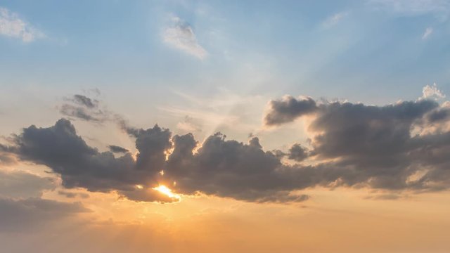 Cloudscape timelapse of sunset sky clouds with nice blue and yellow colors and sunlight through clouds. Sunset sky clouds. Sunset sky background. Beautiful clouds in the sky with sunbeam at sunset