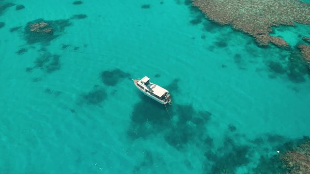 Aerial view of coral reef being explored by boat