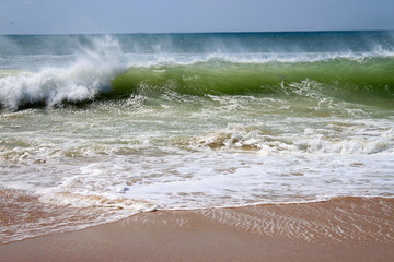 Fototapeta na wymiar Crashing waves on the beach shore
