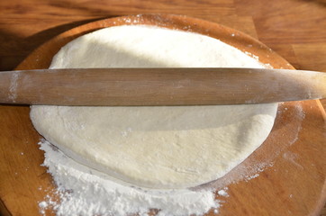 Homemade food. On the board lies a freshly kneaded dough made from wheat flour for making dumplings.
