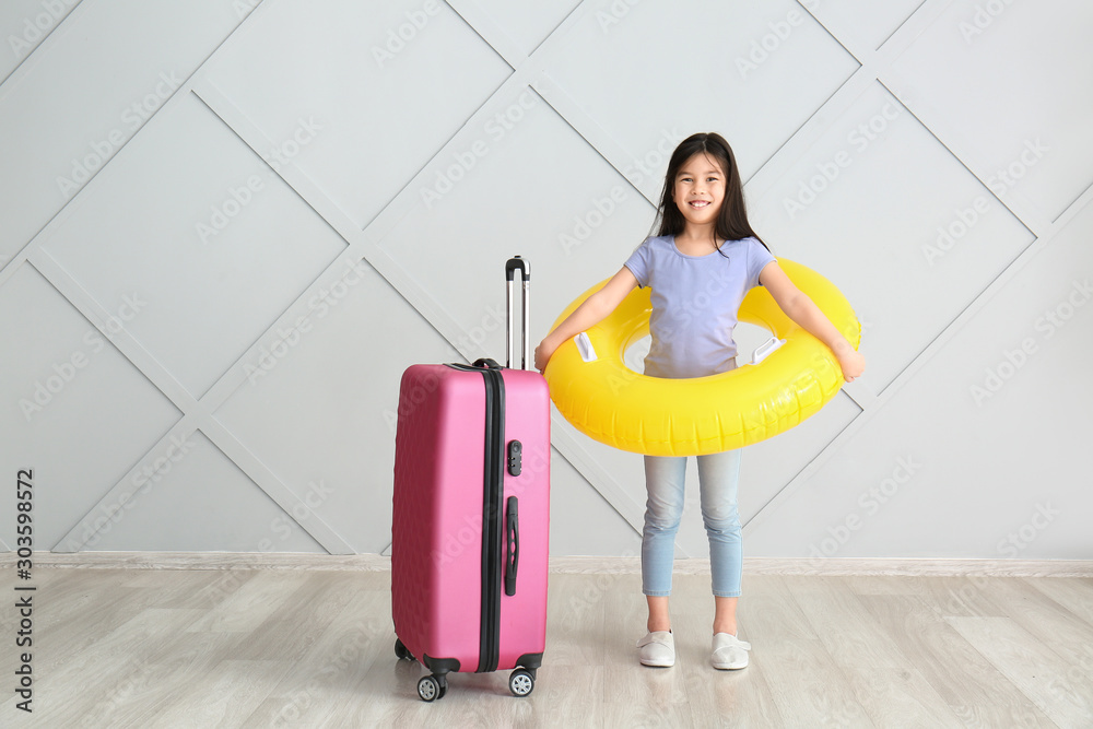 Sticker Cute girl with suitcase and inflatable ring near grey wall