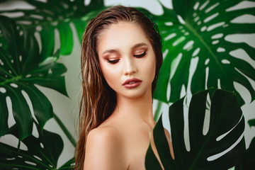 young attractive woman with fashion makeup posing with a fresh green leaf