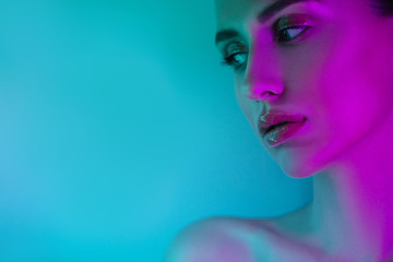 High Fashion woman in colorful bright neon uv blue and purple lights, posing in studio, beautiful girl, glowing make-up, colorful make up.