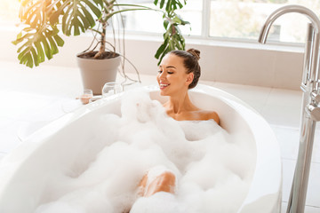 Obraz na płótnie Canvas Beautiful young woman relaxing in bathtub