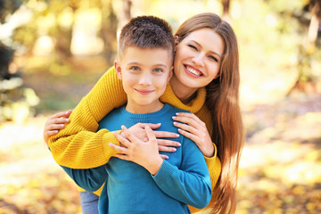 Happy mother and son outdoors on autumn day