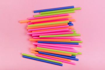 Fototapeta premium colored tubules for juice and cocktails on pink background. Colorful drink straws. straw, plastic free, reusable plastic drinking background, plastic free. Plastic pollution concept.