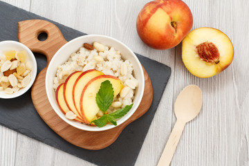 Sorghum salad with nuts and fresh peach on stone board.