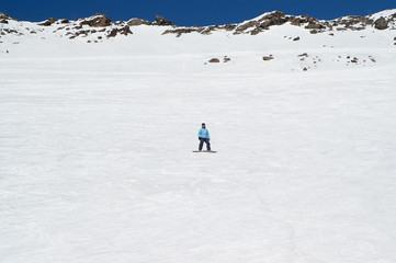 Fototapeta na wymiar Snowboarder on off-piste ski slope in high snowy mountains