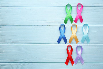 Different awareness ribbons on color wooden background