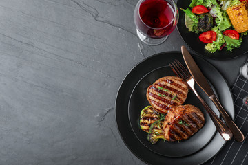 Delicious beef medallions served on grey table, flat lay. Space for text