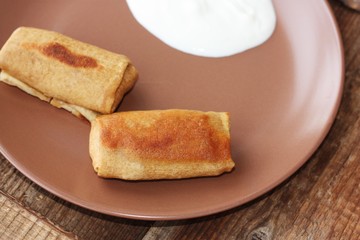 Delicious crepe with sour cream in a plate 