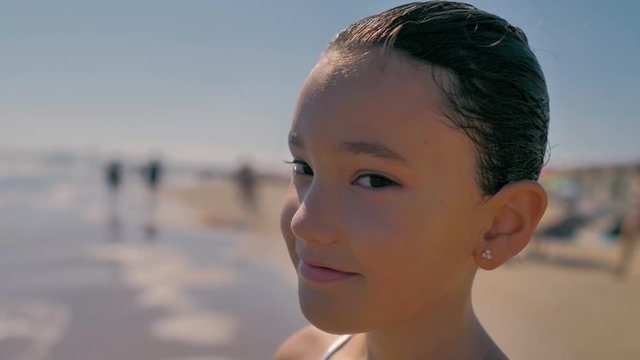 ni&ntilde;a sonriente en la orilla de la playa