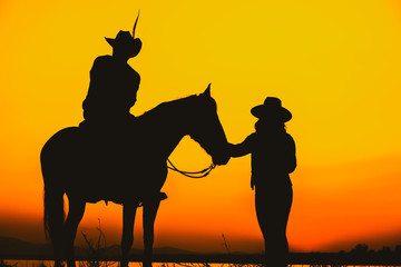 Fototapeta na wymiar Silhouette Cowboy and horse with sunset.