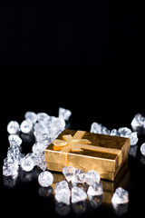 Golden jewellery box with diamonds on a black glossy background