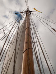 Obraz premium Mast, ropes and sails collected from an old sailboat seen from below