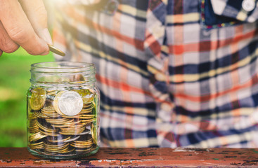 businessman putting coin stacking in to glass jar count the money for saving concept. budgeting for investment startup business.