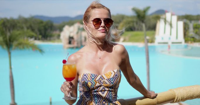 Delighted woman with cocktail on hotel terrace