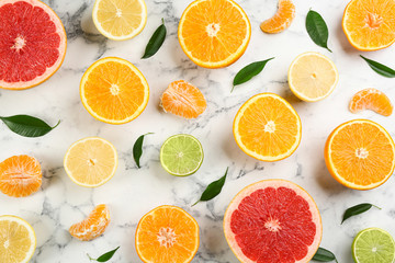 Flat lay composition with tangerines and different citrus fruits on white marble background