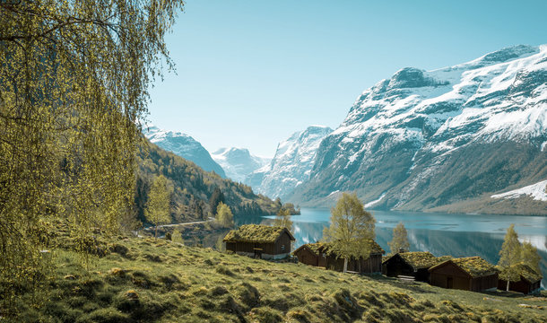 Beautiful norwegian landscape with old farm, lake and mountains