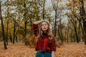 Autumn mood. Fall lifestyle portrait of brunette with long curly hair. Young beautiful Casual joyful woman having fun in fall city park