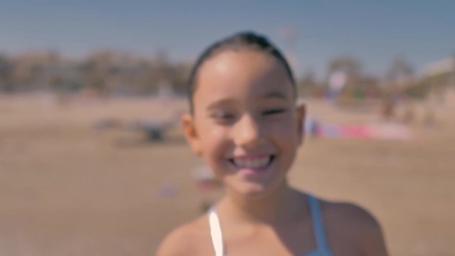 ni&ntilde;a sonriente con ba&ntilde;ador plateado en la playa