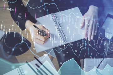 Forex chart hologram on hand taking notes background. Concept of analysis. Multi exposure