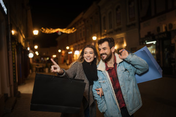 Close up of a young couple shopping in the city at night