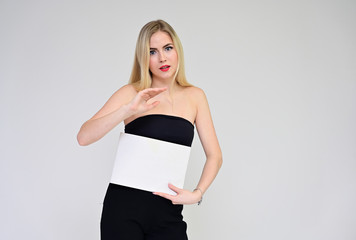 Business training concept with a girl. Portrait of a fashionable beautiful blonde model with long hair, excellent makeup, on a white background with a folder in her hands.