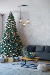 Interior of modern living room with comfortable sofa decorated with Christmas tree and gifts