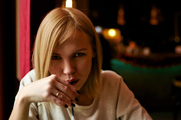 Woman drinking a cocktail from a straw in a cafe.