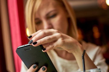 Woman hold mobile phone in cafe.