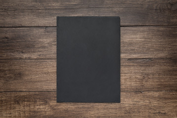 Blank slate board on wooden background