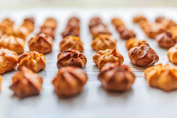 Choux pastry on a light wooden background. Photographed close-up.