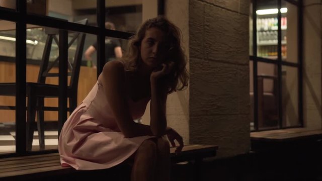 Beautiful girl tired of waiting for a guy on the street. Did not come to a meeting. Long wait. Girl waits for boyfriend for a date and looks nervously. Man didn't come.