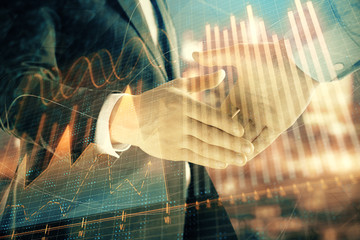 Double exposure of financial chart on cityscape background with two businessmen handshake. Concept of financial analysis and investment opportunities