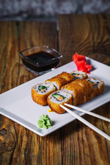 Plate of fried roll on wood background