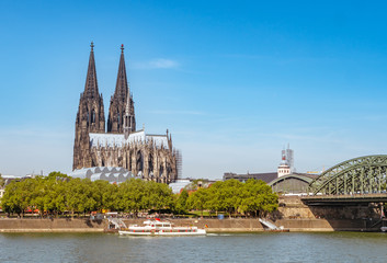 Fototapeta na wymiar Panorama of the Hohenzollern bridge over Rhine river on a sunny day. Beautiful cityscape of Cologne, Germany with cathedral and Great St. Martin Church in the background