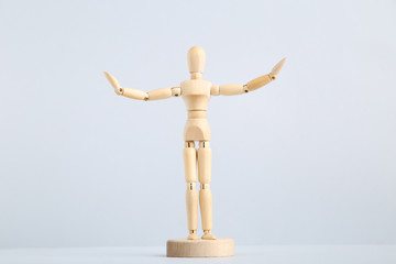 Wooden figure on grey background