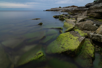 Naklejka na ściany i meble Stone wall on the Baltic sea in the summer. Osmussaar coast, island in Estonia, Europe.
