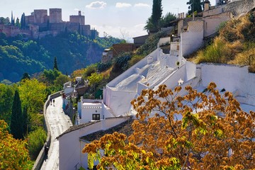 Spanish cave village with Alhambra background - obrazy, fototapety, plakaty