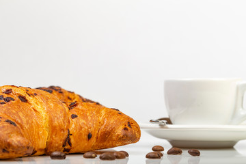 Cornetto al cioccolato con tazza di caffè