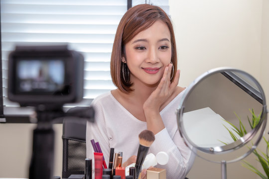 Asian woman beauty vlogger or blogger live broadcast of cosmetic makeup tutorial clip by mobile phone and sharing on social media channel or website, Influencer lifestyle and selfies taking images