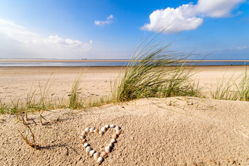 Wonderful dune beach on the North Sea island Langeoog in Germany with sky, clouds, sand, hearts...