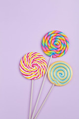 Fototapeta na wymiar rainbow color lollipops on violet background
