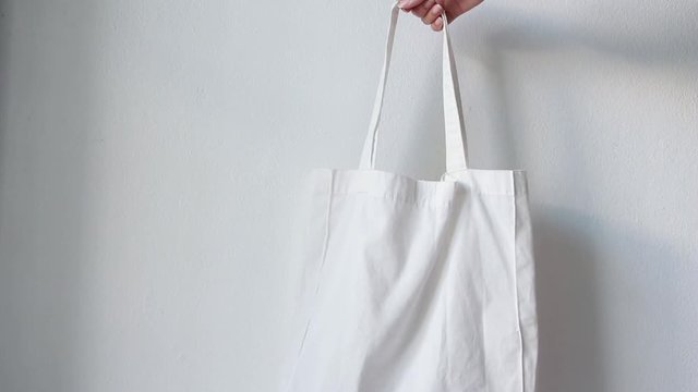 Woman holding canvas tote bag on white background. Reusable Eco bag. Eco friendly concept.