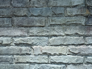 Background. The textured surface of the outer wall of grey stone