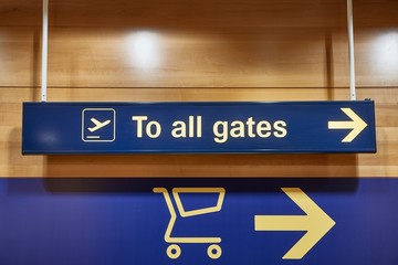 Direction signs inside a large airport, way to the gates