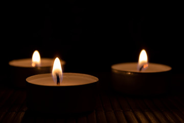Obraz na płótnie Canvas three candles in the dark with copy space