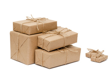 Pile of stacked boxes wrapped with brown kraft paper and tied with twine on a white background. Delivery, moving, package and gifts concept. Copy space