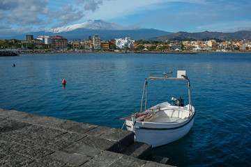 Obraz premium Giardini-Naxos touristic resort with beautiful Etna volcano covered with snow on Sicili, Italy